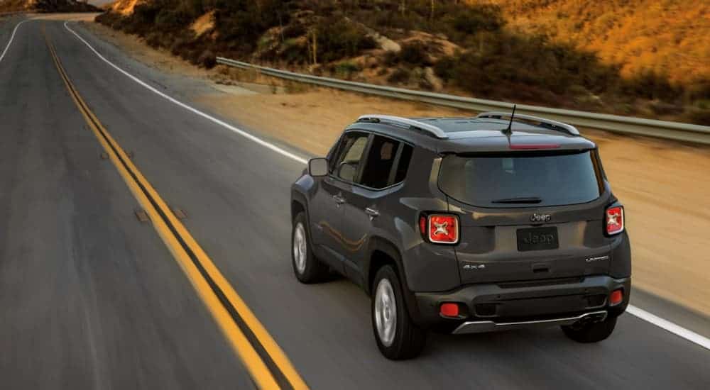 A charcoal 2020 Jeep Renegade is driving on a highway.