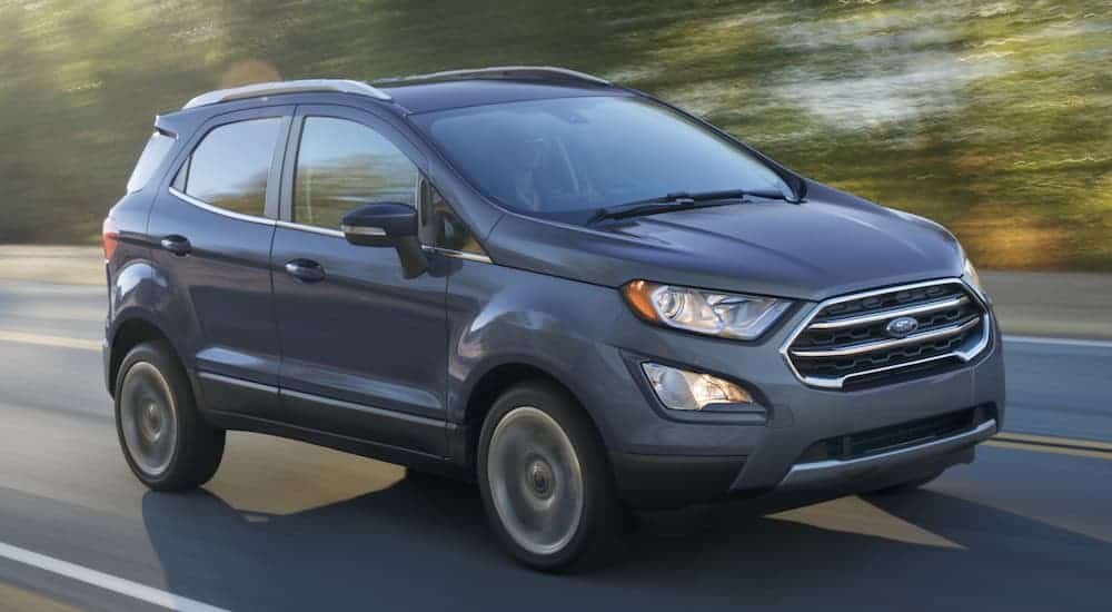 A grey 2020 Ford Ecosport is driving on a highway with a sun glare.
