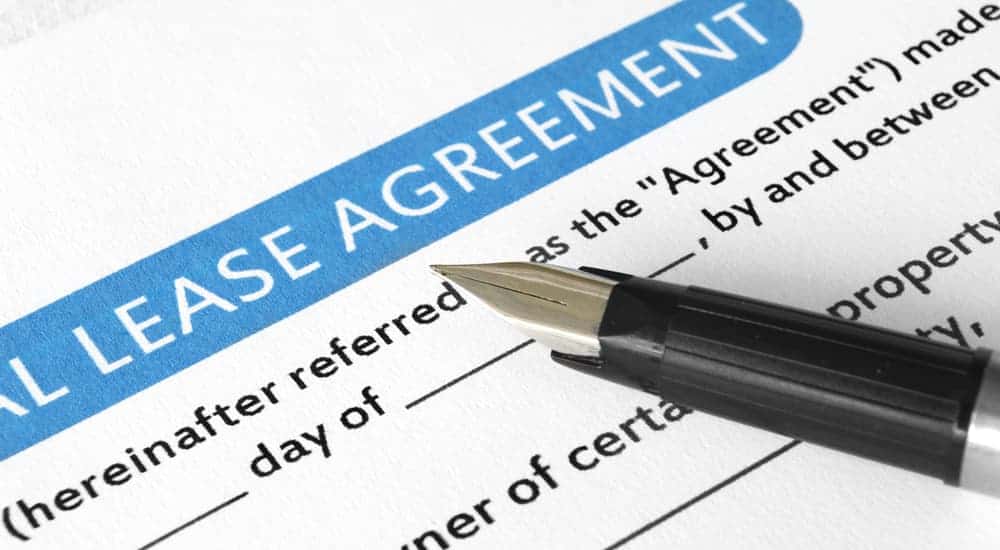 A pen is on a paper that says 'lease agreement.'