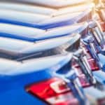 A line of cars at a car dealership is shown.
