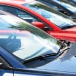 A row of used cars parked on a dealerships lot.