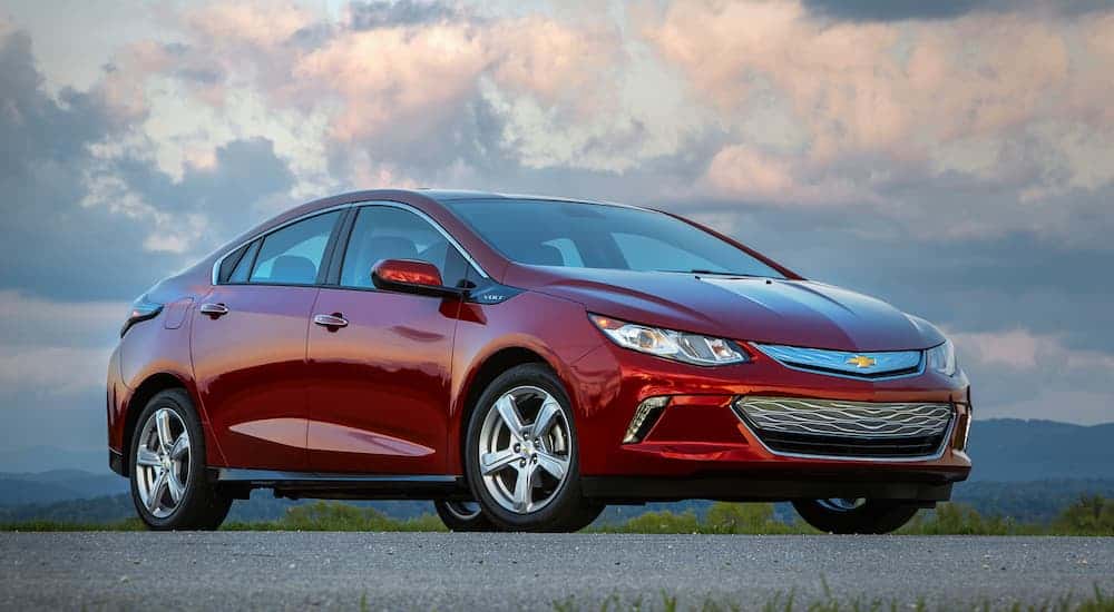 A red 2019 Chevy Volt is parked in an empty parking lot at dusk. 