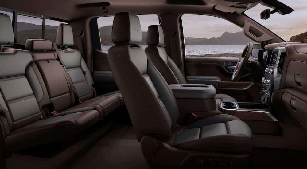 A side view of the front and rear brown and black leather interior of a 2020 GMC Sierra 1500 is shown. 