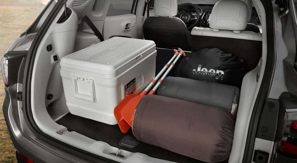 The rear of a 2020 Jeep Compass is shown packed with camping equipment. 