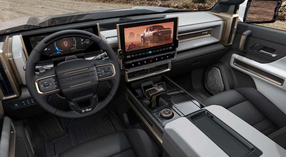 The grey and black interior and infotainment system is shown on a 2022 GMC Hummer EV.