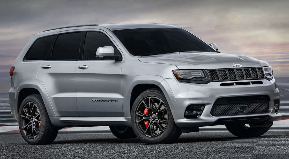 A grey 2020 Jeep Grand Cherokee SRT is parked on a racetrack at dusk.