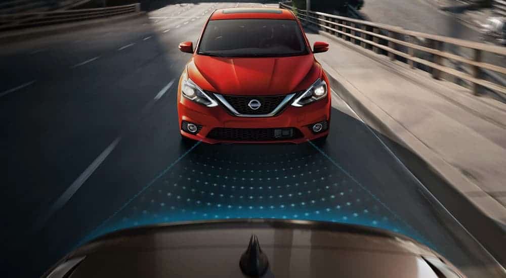 A simulation of the Nissan Intelligent Cruise Control showing blue dots behind a silver vehicle and a red 2019 Sentra approaching from behind