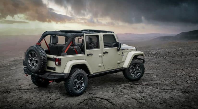 A white 2017 Jeep Wrangler Rubicon Recon Edition is off-road near a cliff with a view.