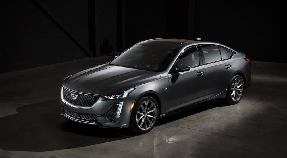 A grey 2020 Cadillac CT5, which is a popular option among 2020 Cadillacs for sale, is parked in a dark showroom. 