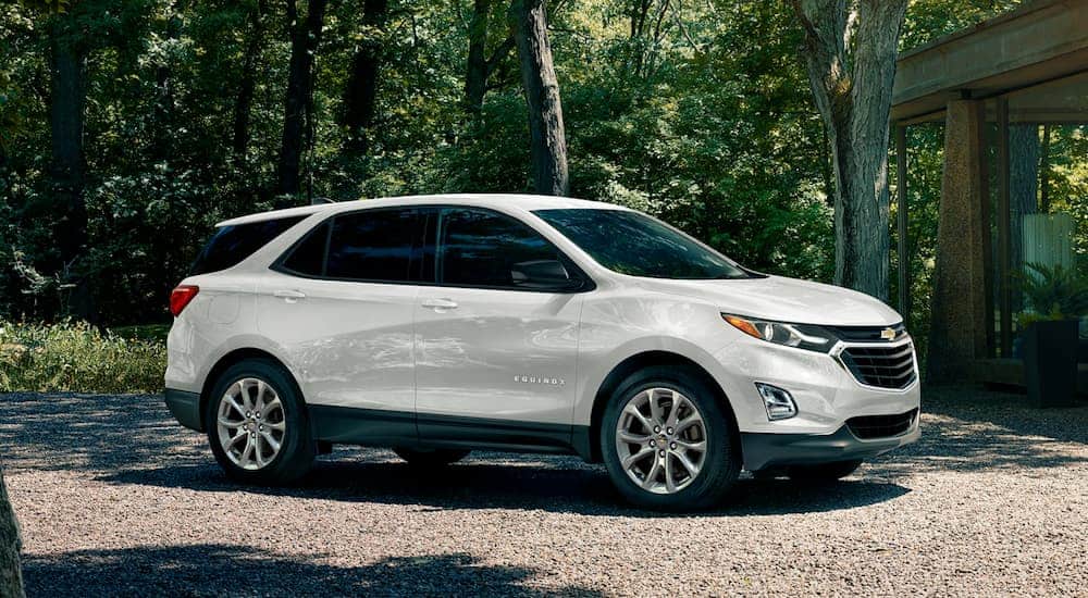 A white 2020 Chevy Equinox is parked on a gravel driveway. 