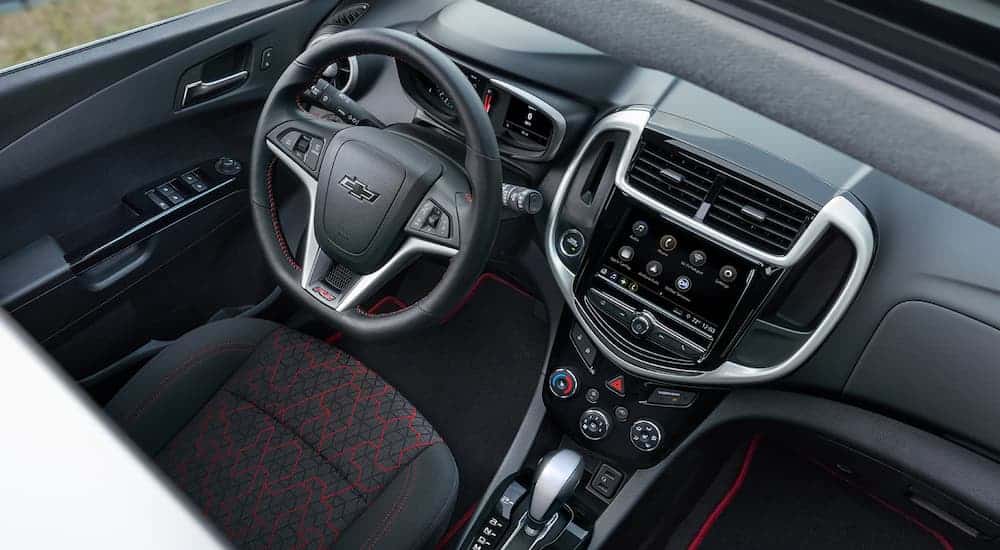 A birds eye view of the front black and red interior of a 2020 Chevy Sonic is shown. 