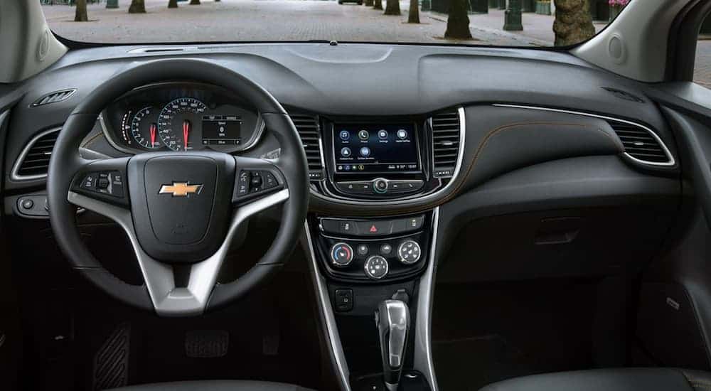 The front black leather interior of a 2020 Chevy Trax is shown. 