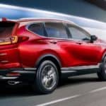 A red 2020 Honda CR-V Touring is driving through a tunnel after leaving a Honda dealer.