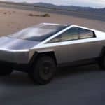 A silver Tesla Cybertruck, which is a hot topic in current auto news, is driving around a racetrack.