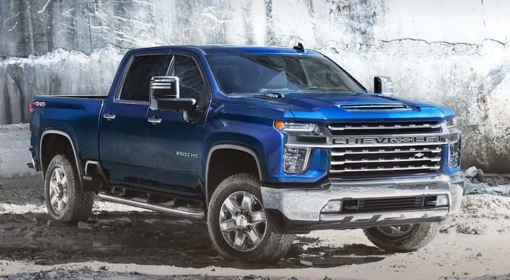 A blue 2020 Chevy Silverado 2500 is parked in front of a rock wall near Virginia.