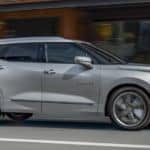 A silver 2020 Chevy Blazer, which wins when comparing the 2020 Chevy Blazer vs 2020 Jeep Cherokee, is driving past blurred buildings.