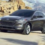 A grey 2020 Ford Escape, which wins when comparing the 2020 Ford Escape vs 2020 Kia Sportage, is driving around a rocky corner.
