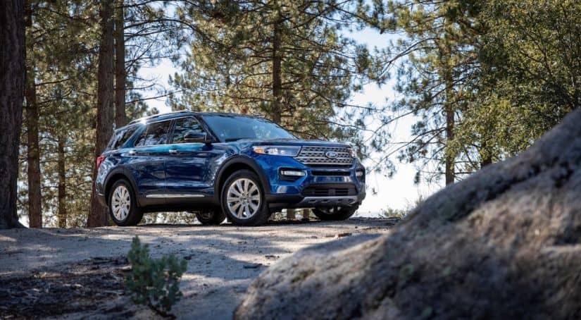 A blue Explorer is parked in the woods victoriously after winning 2020 Ford Explorer vs 2020 Toyota Highlander.