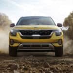 The front of a yellow 2021 Kia Seltos on a dirt trail