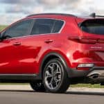 A red 2020 Kia Sportage is shown parked from the rear while waiting for a comparison on the 2021 Kia Sportage vs 2020 Kia Sportage.