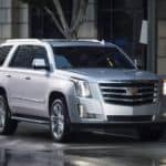 A silver 2018 Cadillac Escalade is parked on a city street.
