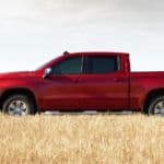 A red 2020 Chevy Silverado 1500, which wins when comparing the 2020 Chevy Silverado 1500 vs 2020 Toyota Tundra, is parked in a grassy field.