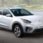 A white 2019 Kia Niro is charging at a roadside station.
