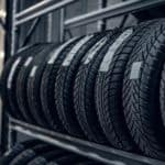 A row of tires are shown at a tire shop.