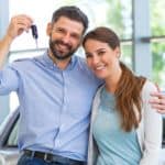 A husband is holding up the keys to the car a couple just bought after discovering that what's old is new again.