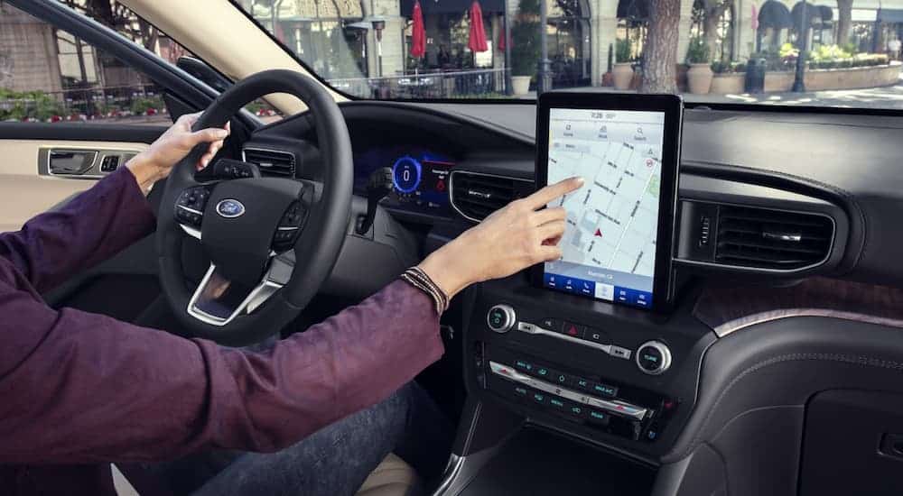 A woman is using the touchscreen in a 2020 Ford Explorer.