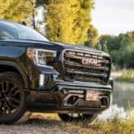A black 2020 Sierra Elevation is parked in front of a pond after winning 2020 GMC Sierra 1500 vs 2020 Chevy Silverado.