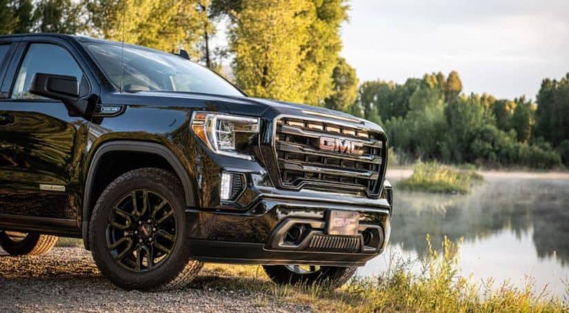 A black 2020 Sierra Elevation is parked in front of a pond after winning 2020 GMC Sierra 1500 vs 2020 Chevy Silverado.
