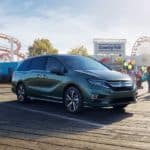 A green 2020 Honda Odyssey Elite is parked in front of a county fair.