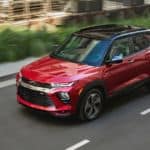 A red 2021 Chevy Trailblazer RS is driving past bushes after winning the 2021 Chevy Trailblazer vs 2020 Nissan Kicks comparison.