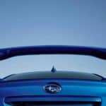 The spoiler on a blue 2020 Subaru WRX is shown from a low angle.
