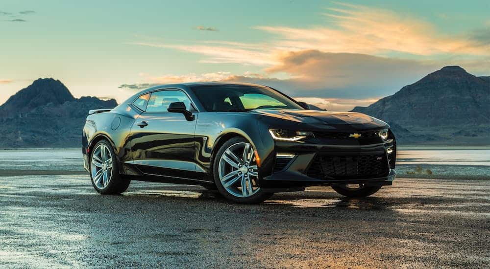 A black 2017 Chevy Camaro SS is parked in front of the ocean and islands.