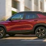 A red 2021 Chevy Trailblazer RS is driving on a city street.