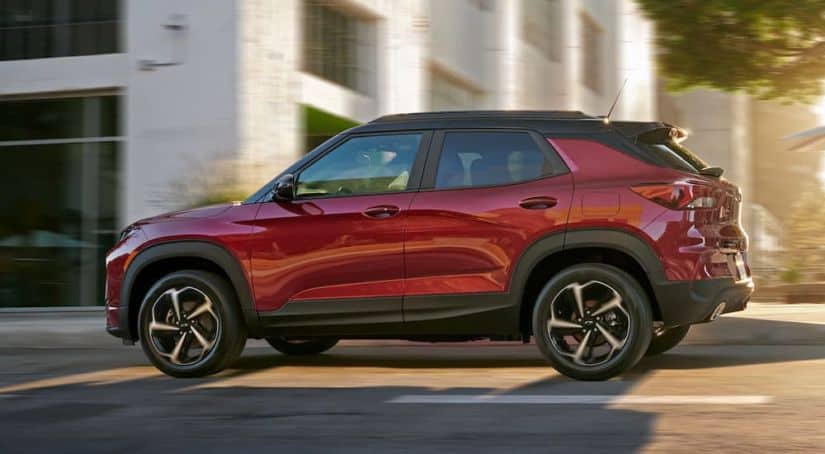 A red 2021 Chevy Trailblazer RS is driving on a city street.