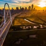 A drone view of Dallas, TX, during sunset is shown.