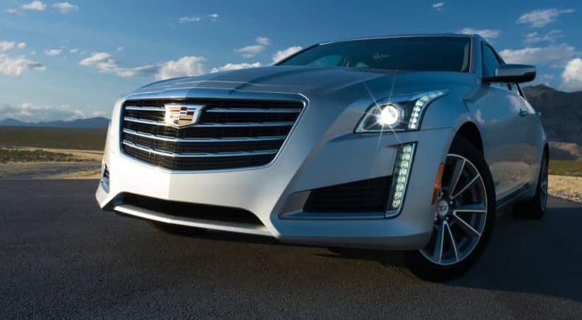 A silver 2017 used Cadillac CTS is shown against a blue sky.