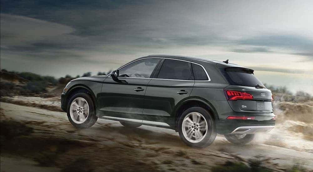 A gray 2020 Audi Q5 is driving in the desert.