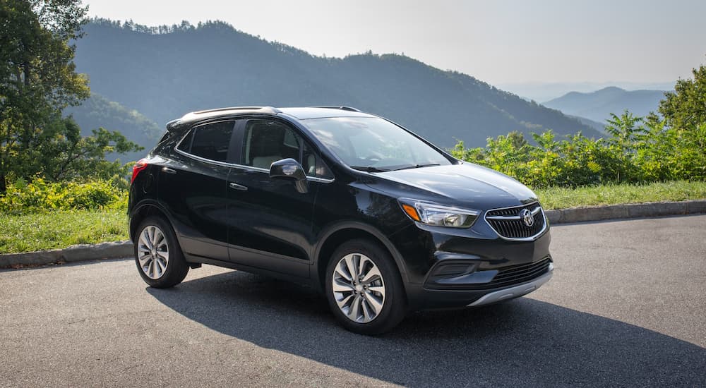 A black 2020 Buick Encore is parked with mountains in the distance.