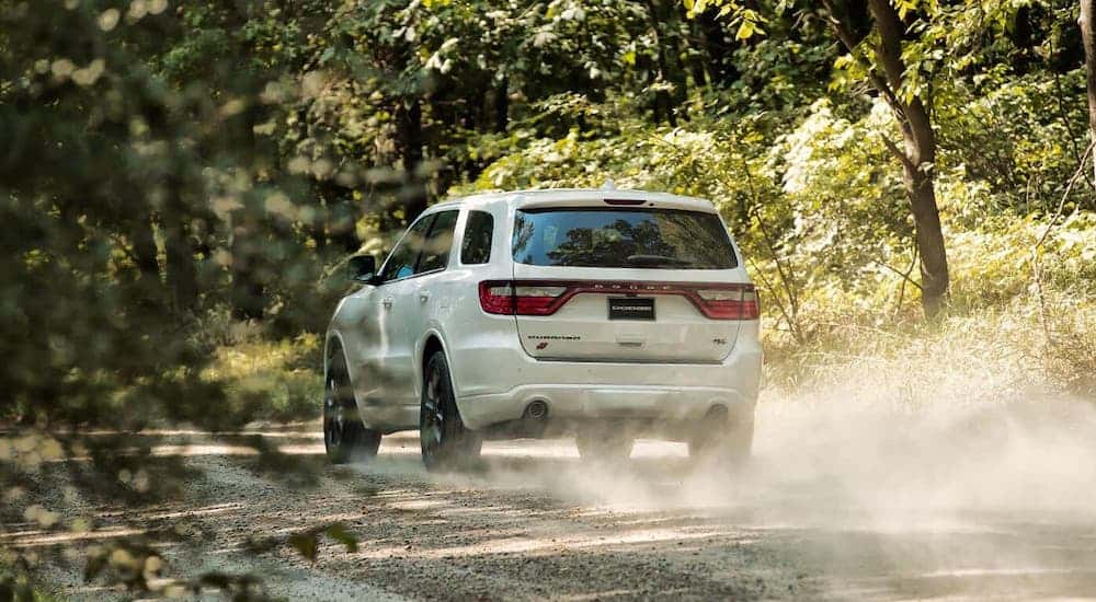 The rear is shown of a white 2020 Dodge Durango driving on a dirt road after losing the 2020 Ford Edge vs 2020 Dodge Durango comparison.