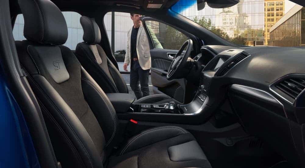 A man is about to enter the driver's seat in a 2020 Ford Edge, shown from the passenger seat.