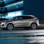 A silver 2020 Ford Edge is parked on a city street at night.