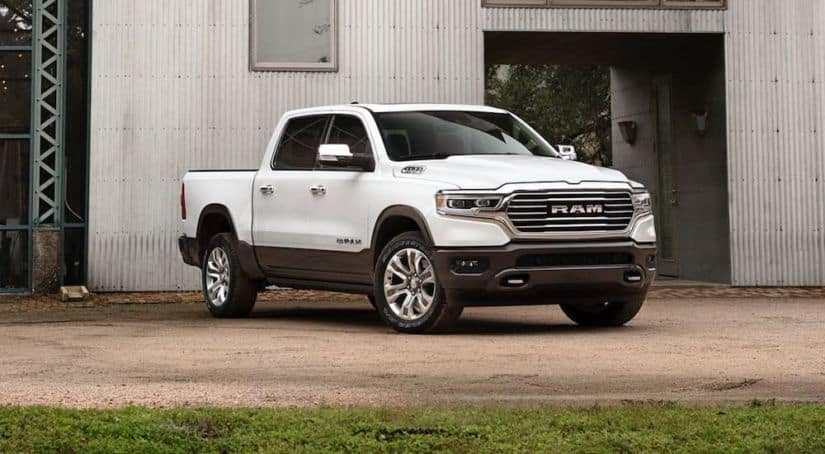 A white 2020 Ram 1500 is parked in front of a white barn after winning the 2020 Ram 1500 vs 2020 Nissan Titan comparison.