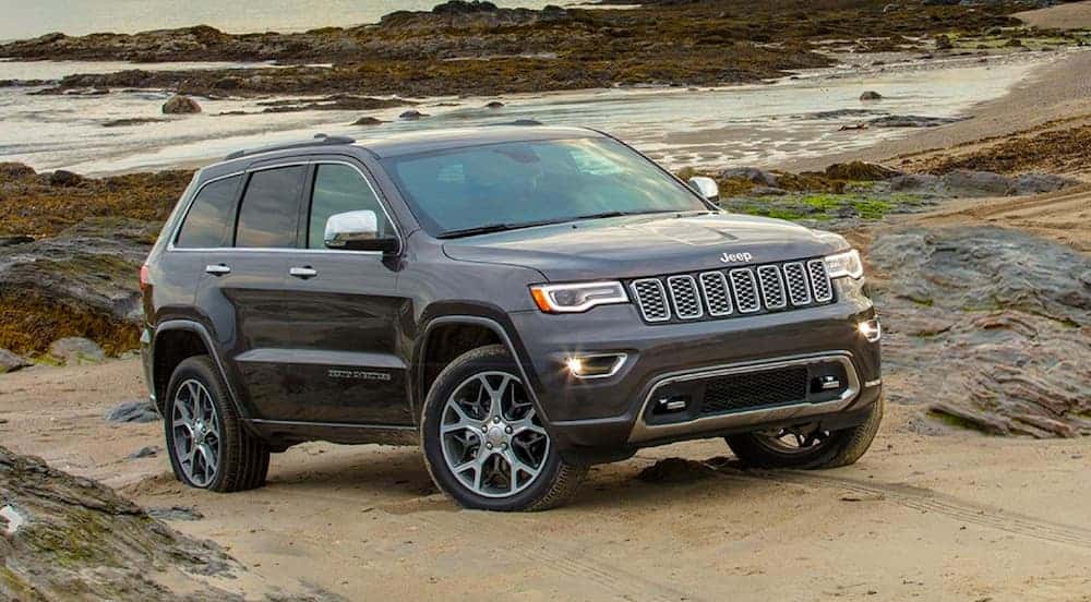 A grey 2020 Jeep Grand Cherokee is on the beach.