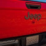 A closeup is shown of the tailgate on a red 2020 Jeep Gladiator, a popular Jeep lease.