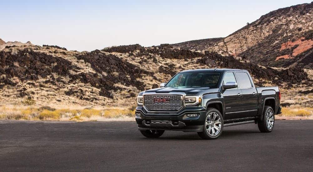 A black 2018 GMC Sierra is parked in front of hills.