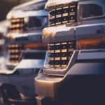 A row of used trucks are shown with a focus on the grilles.